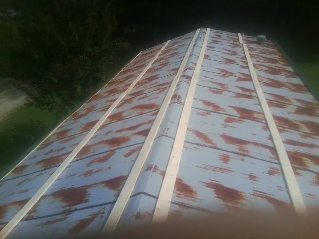 Rusted metal roof panels with new wood purlins before replacement — Storm Damage Roof Repair in Byrdstown by Roofing Brothers