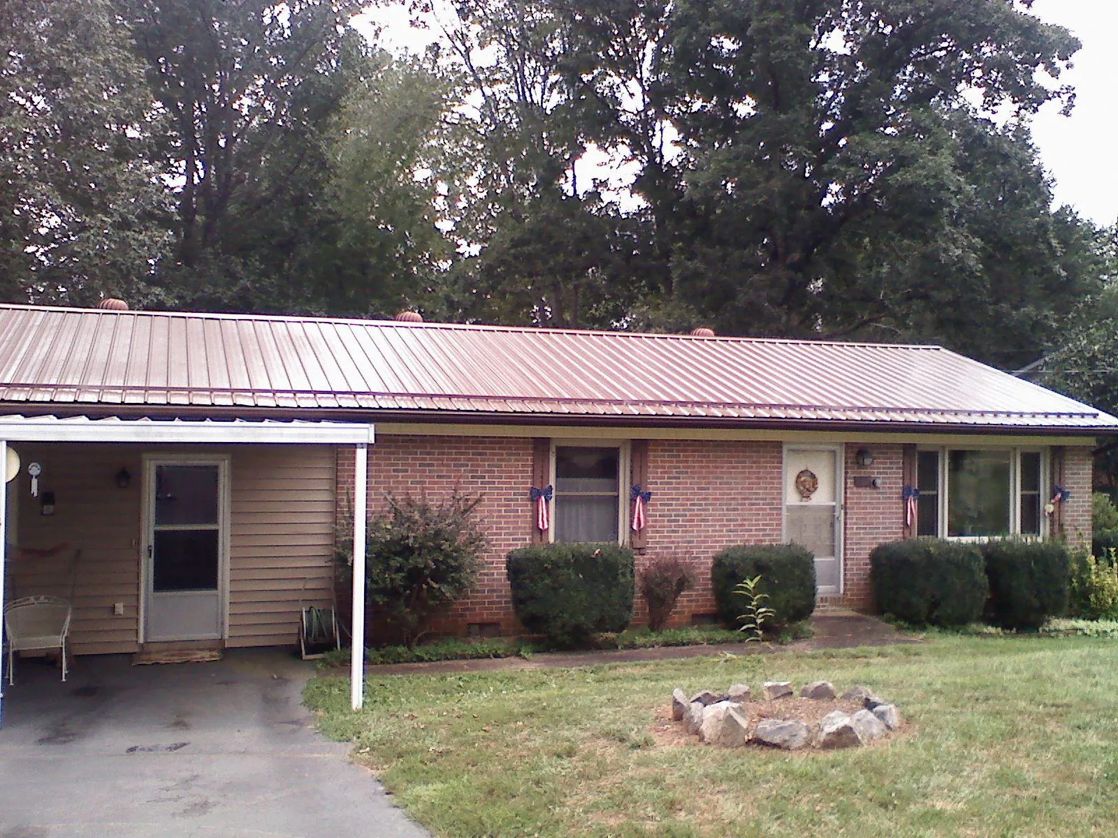 Bronze metal roof and carport on a brick ranch home — Roof Repair work by our crew in Byrdstown
