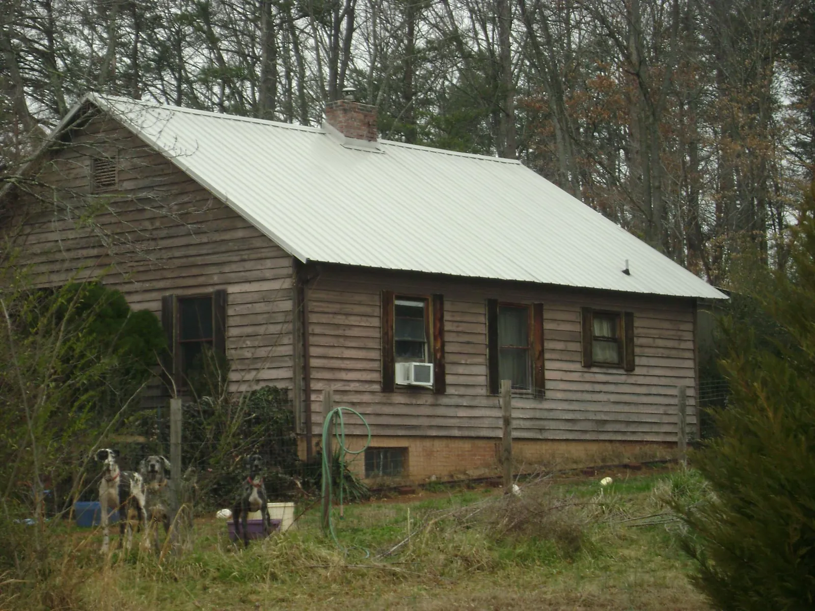 White metal roof on an old wood sided farmhouse, from a Metal Roof Installation job in Byrdstown